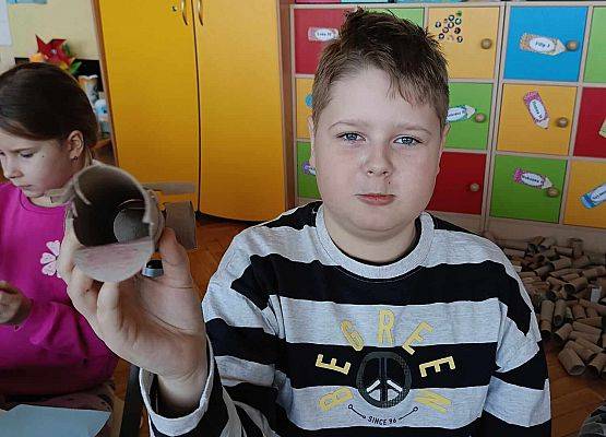 chłopiec pokazuje swoją pracę