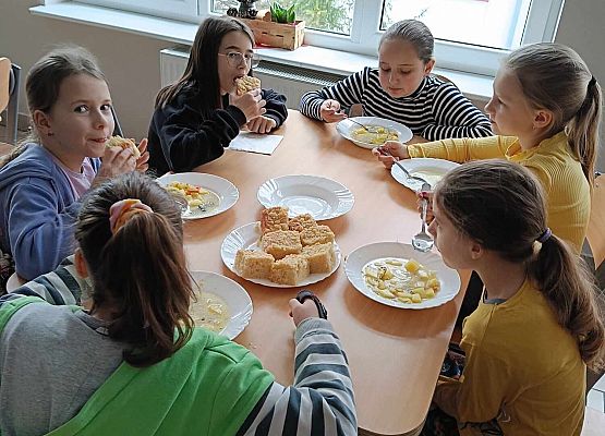 dzieci siedzą w stołówce p-odczas posiłku