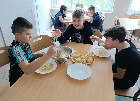 dzieci siedzą w stołówce p-odczas posiłku