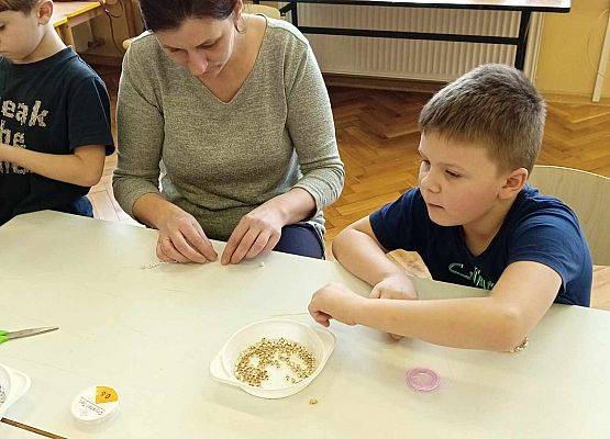 chłopiec z mamą tworzy biżuterię