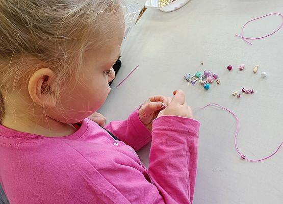 dziewczynka nawleka koraliki
