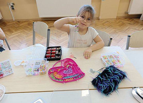 dziewczynka nawleka koraliki