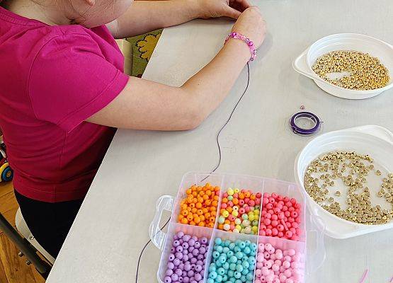 dziewczynka nawleka koraliki