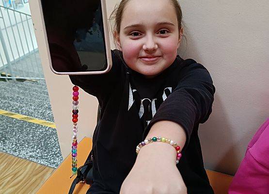 dziewczynka prezentuje wykonaną biżuterię