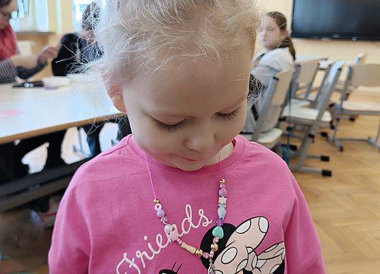 dziewczynka prezentuje wykonaną biżuterię