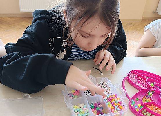 dziewczynka tworzy biżuterię