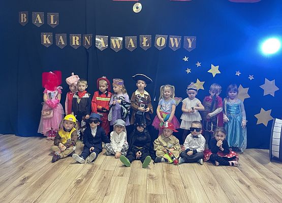 zdjęcie grupowe dzieci na tle napisu bal karnawałowy