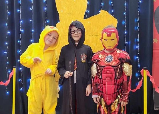 dzieci w przebraniach pozują do zdjęcia na czerwonym dywanie