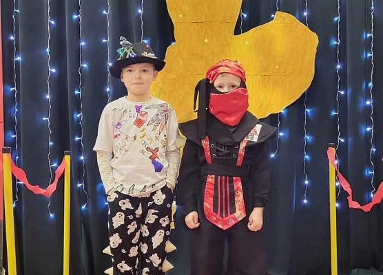 dzieci w przebraniach pozują do zdjęcia na czerwonym dywanie