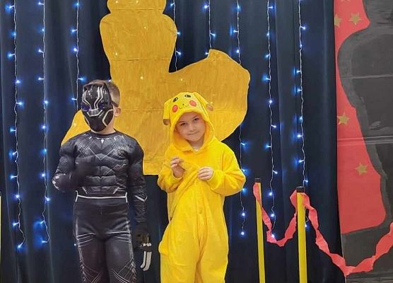 dzieci w przebraniach pozują do zdjęcia na czerwonym dywanie