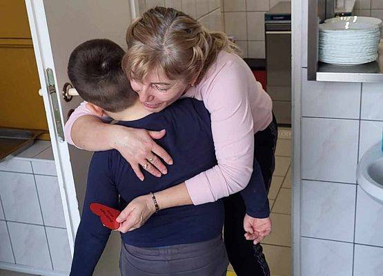 chłopiec wręcza serduszko z napisem