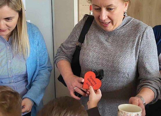 chłopiec wręcza serduszko z napisem