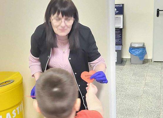 chłopiec wręcza serduszko z napisem