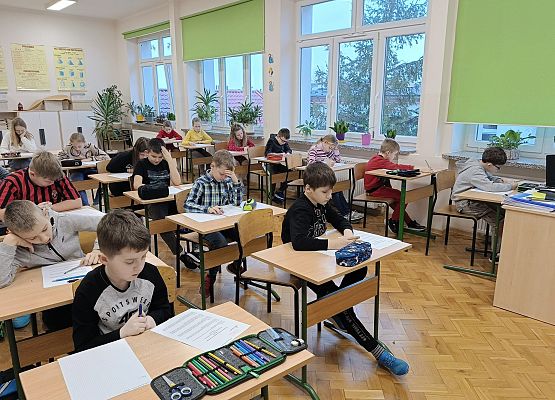 uczestnicy konkursu siedzą przy stolikach