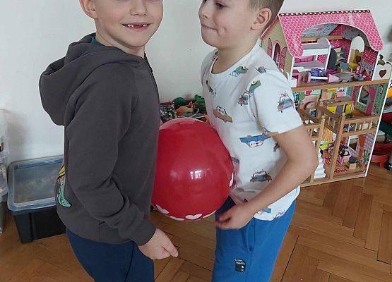 chłopcy tańczą z balonem
