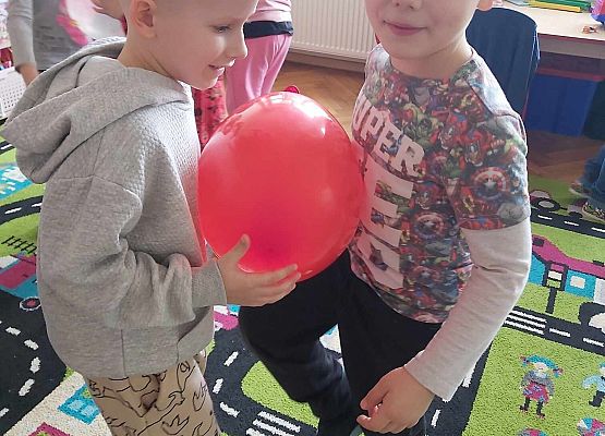 chłopcy tańczą z balonem