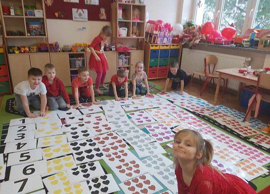dzieci układają na dywanie kolorowe serca