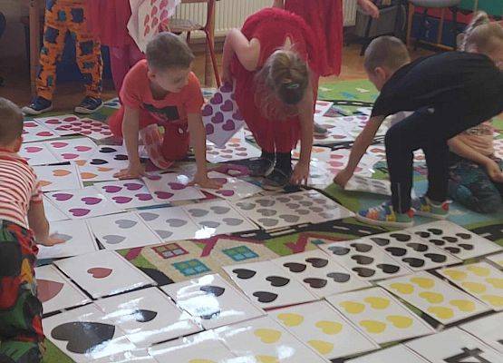 dzieci układają na dywanie kolorowe serca