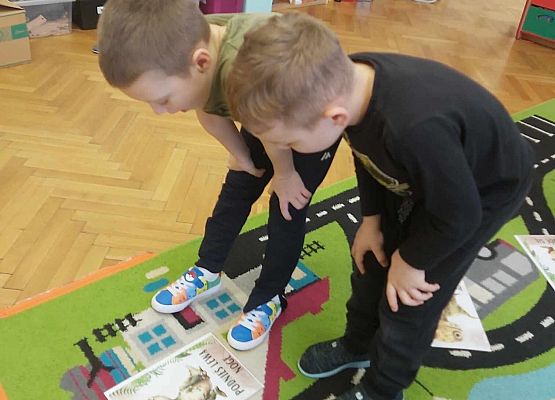 chłopcy wykonują zadanie na dywanie