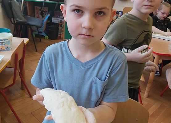 chłopiec prezntuje wykonaną figurkę z masy solnej
