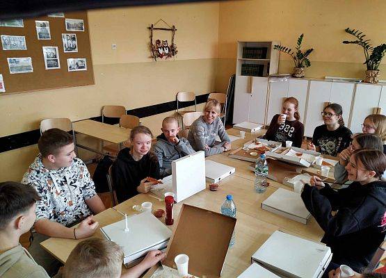 uczniowie jedzą pizzę