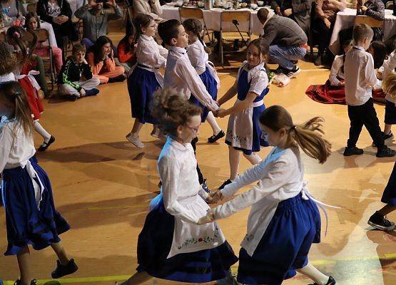 dzieci w strojach kaszubskich tańczą na scenie