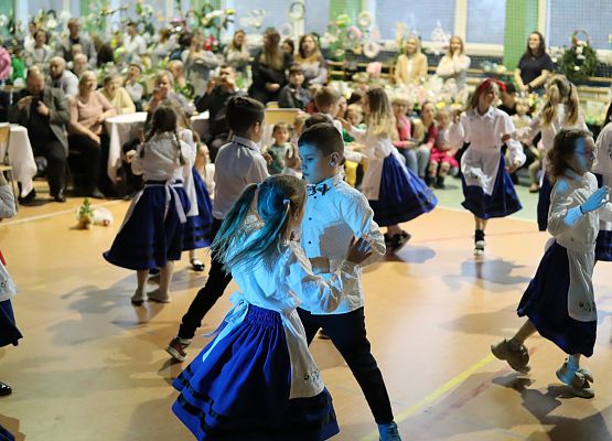 dzieci w strojach kaszubskich tańczą na scenie