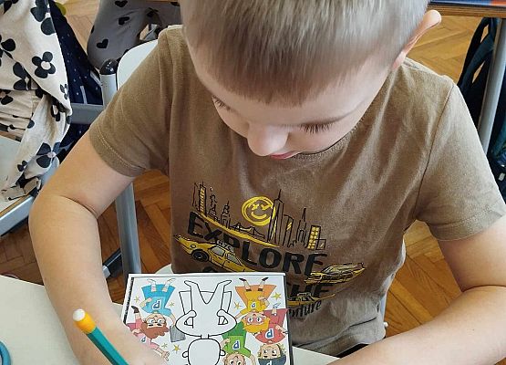 chłopiec uzupełnia książeczkę