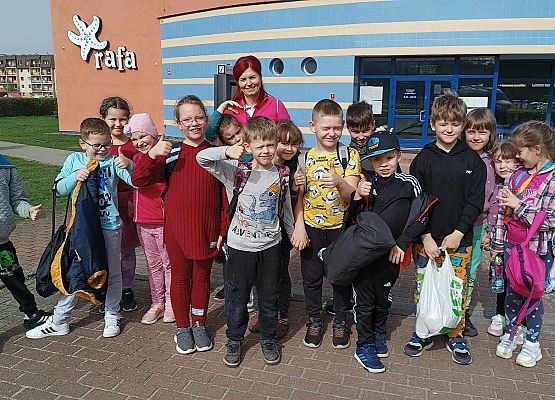 nauczycielka z uczniami przed budynkiem