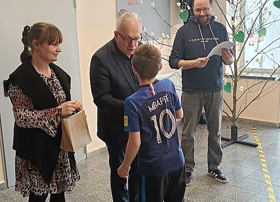 uczeń odbiera nagrodę i dyplom