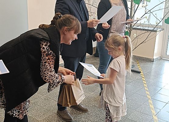 uczennica odbiera dyplom i nagrodę