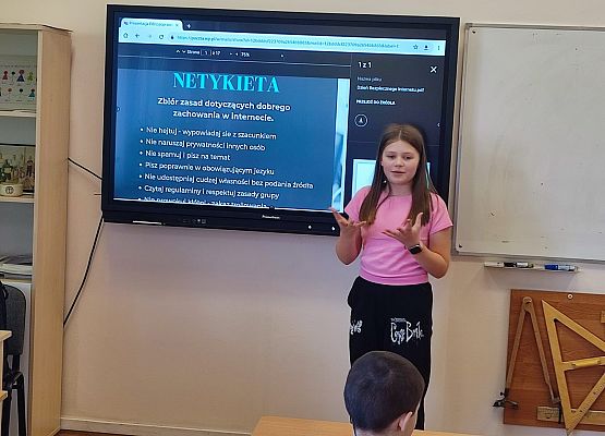 uczennica stoi przy tablicy multimedialnej