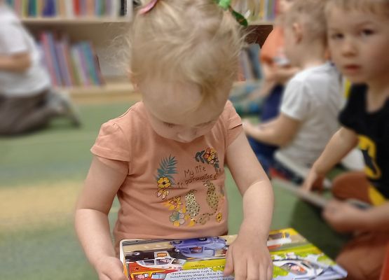 dziewczynka ogląda książeczkę