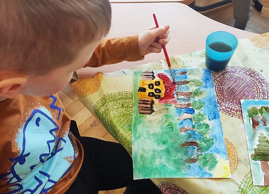 chłopiec maluje farbkami