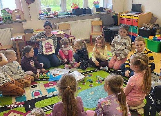 nauczycielka pokazuje dzieciom ilustracje