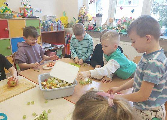 dzieci przygotowują sałatkę owocową
