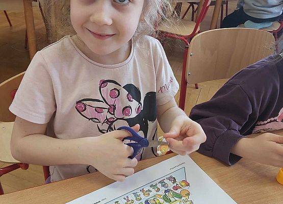 dziewczynka układa produkty na piramidzie zdrowego żywienia