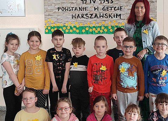 uczniowie z nauczycielką przy gazetce tematycznej