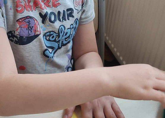 uczeń składa papierowego żonkila