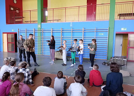 uczniowie siedzą w sali i oglądają scenki