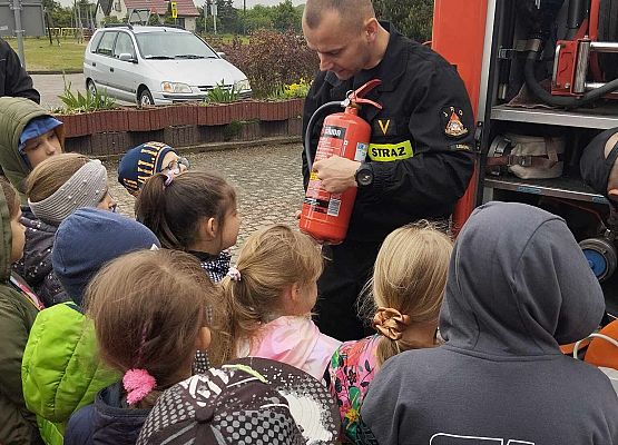 strażak prezentuje dzieciom gaśnice