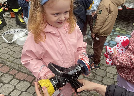 dziewczynka ogląda sprzęt strażacki