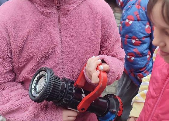 dziewczynka ogląda sprzęt strażacki