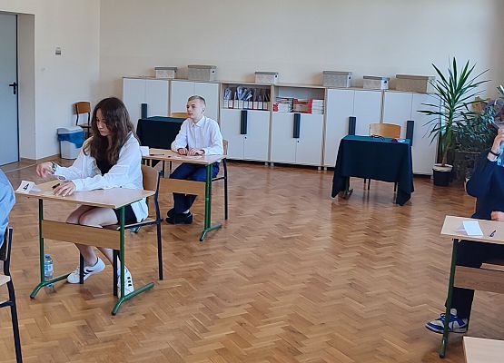 uczniowie siedzą przy stolikach