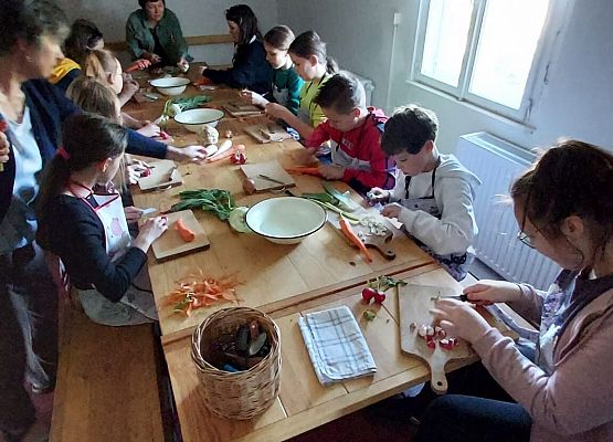 uczniowie kroją warzywa do zupy