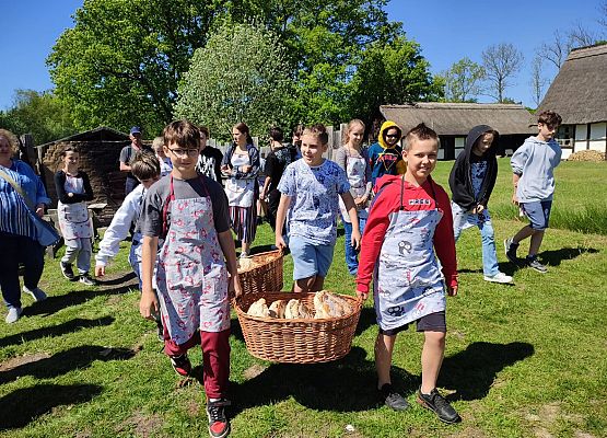 uczniowie niosą chleb