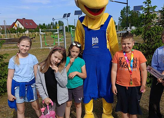 dzieci stoją obok maskotki