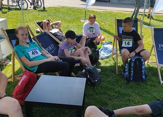 uczniowie siedzą na leżakach i oczekują na wyniki turnieju