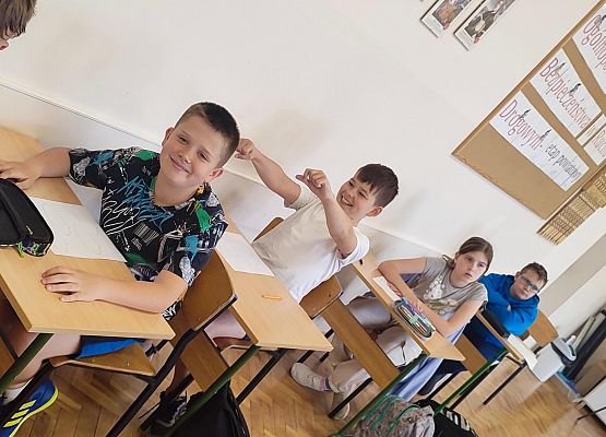 uczniowie siedzą w ławkach podczas zajęć