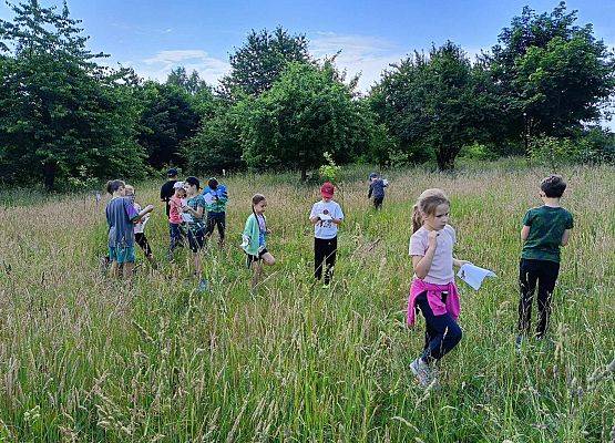 uczniowie biegają po trawie